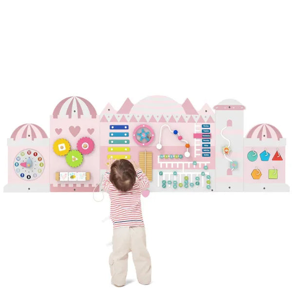 Child playing with a colorful educational toy shaped like a town on a white background