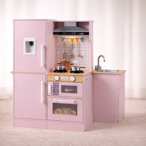 Pink toy kitchen set with wooden counter and appliances on a light background