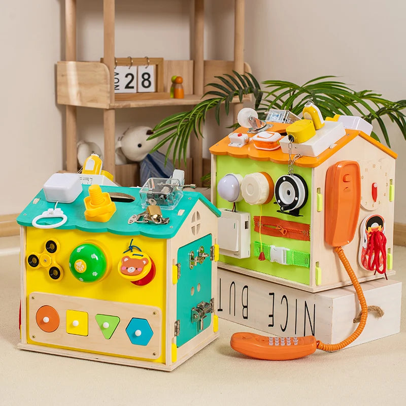 Colorful wooden toy houses with various interactive elements on a neutral background.