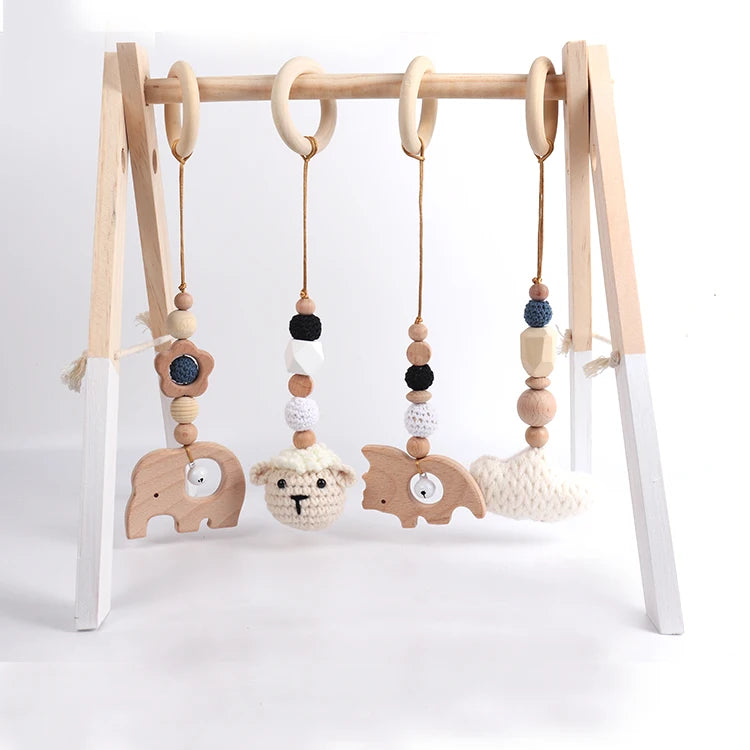 Wooden baby gym with hanging toys on a white background