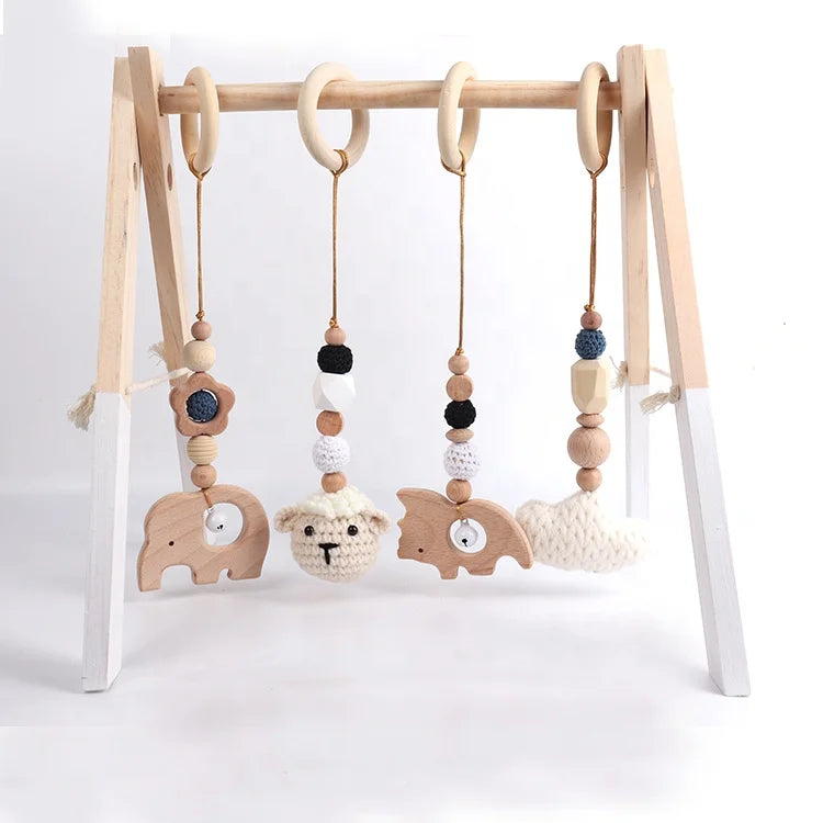 Wooden baby gym with hanging toys on a white background