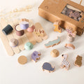 Set of wooden toys with animal shapes and a cardboard box on a light background
