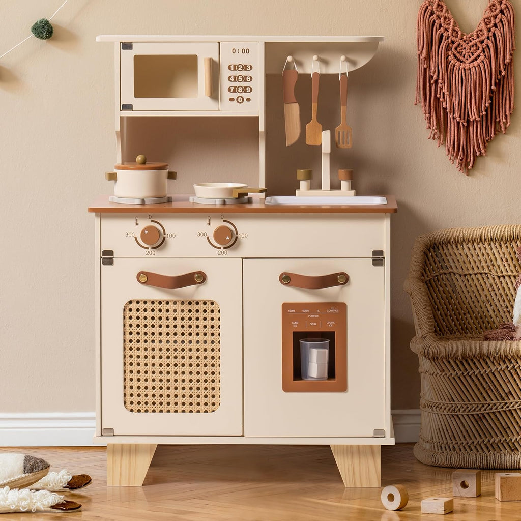 Children's play kitchen set with wooden cabinets and accessories on a beige wall background.