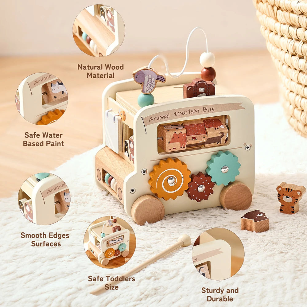 Wooden toy bus with various educational elements on a soft surface